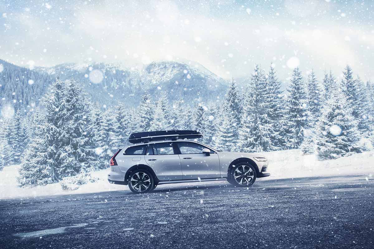 Volvo Auto fährt durch Wald im Winter